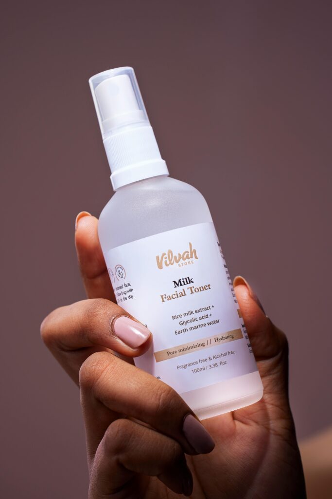 Elegant close-up of a woman holding a skincare milk facial toner bottle for beauty treatment.